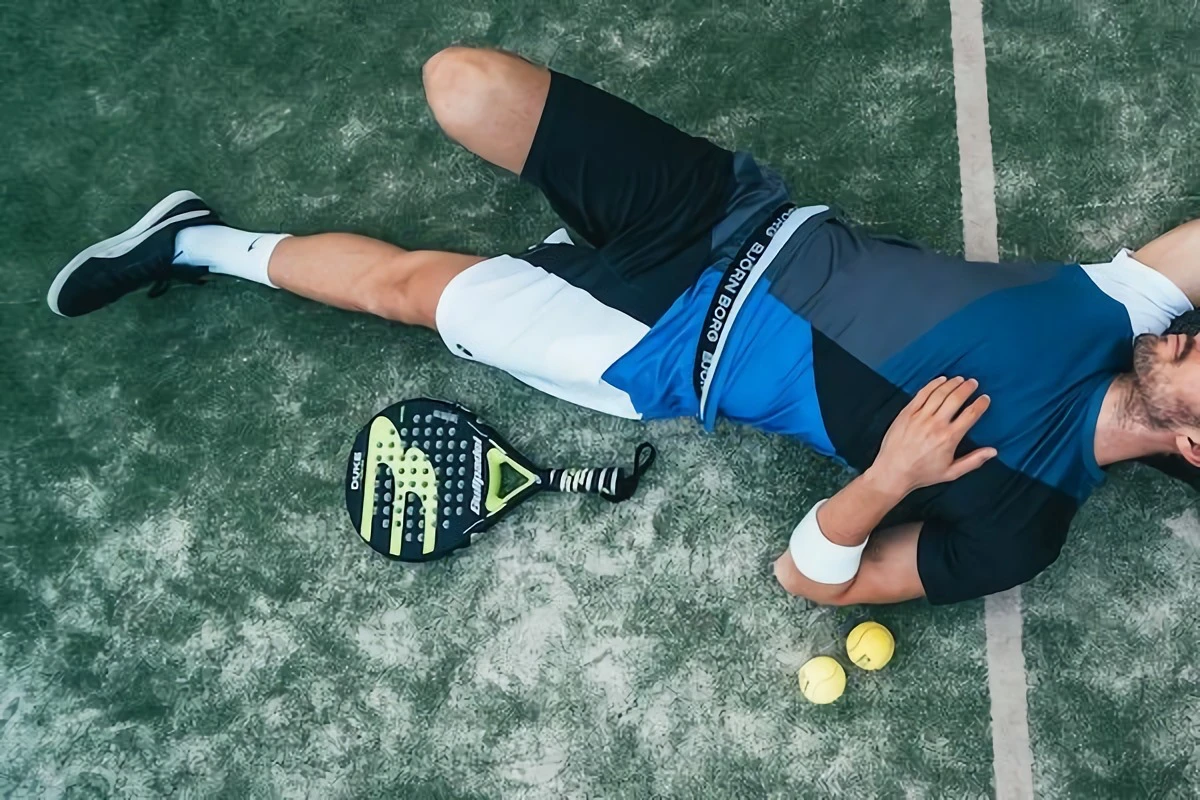 man laying on the floor after tennis