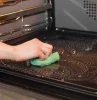 person cleaning an oven