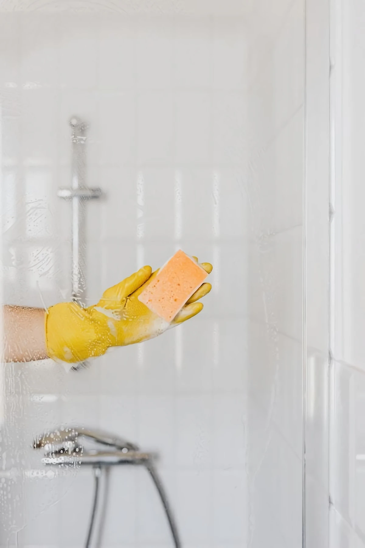 scrubbing shower door with sponge