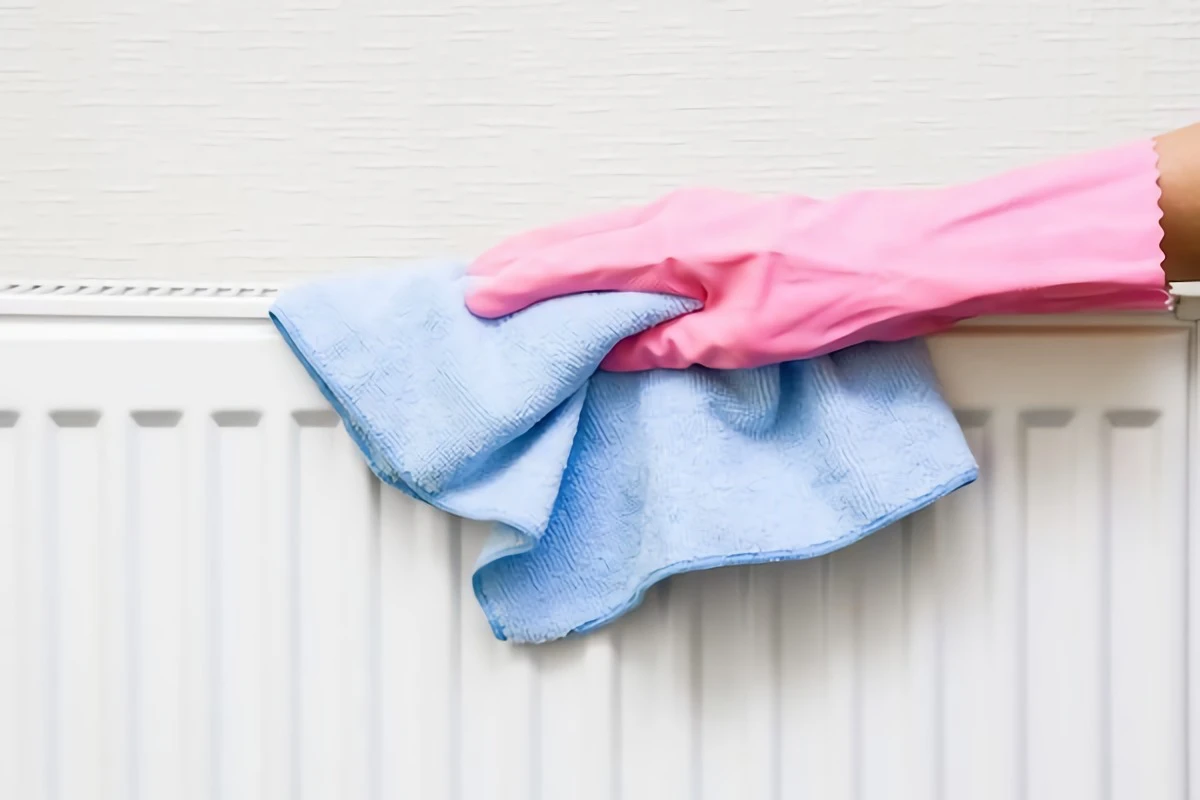 wiping down radiator with cloth