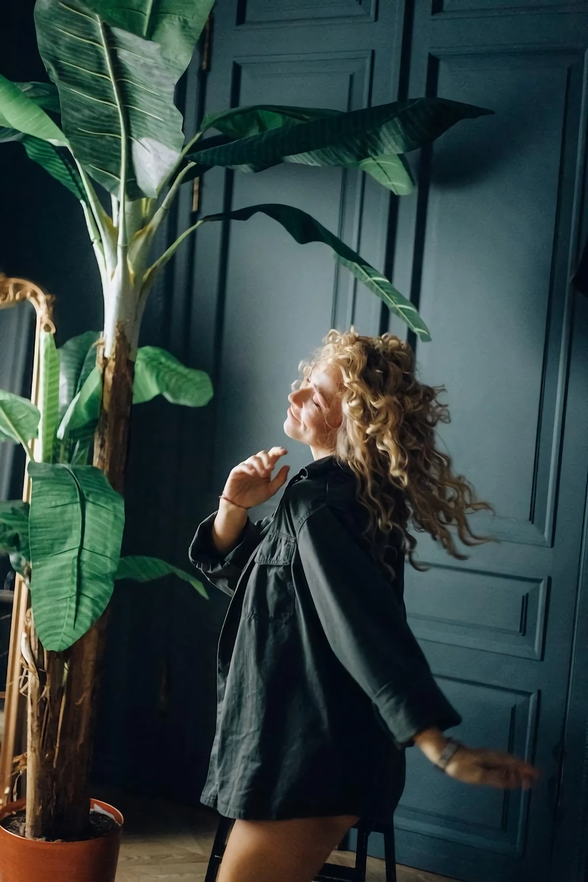 woman dancing in between big plants