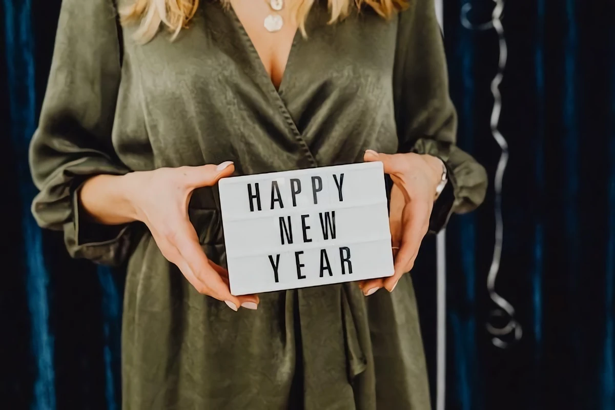 woman holding a happy new year sign