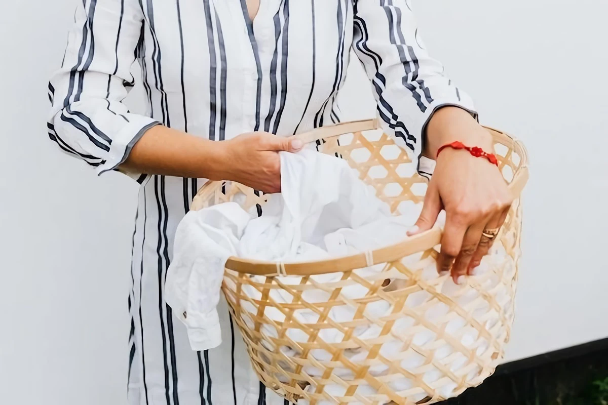 woman holding a laundry basket with white clothes