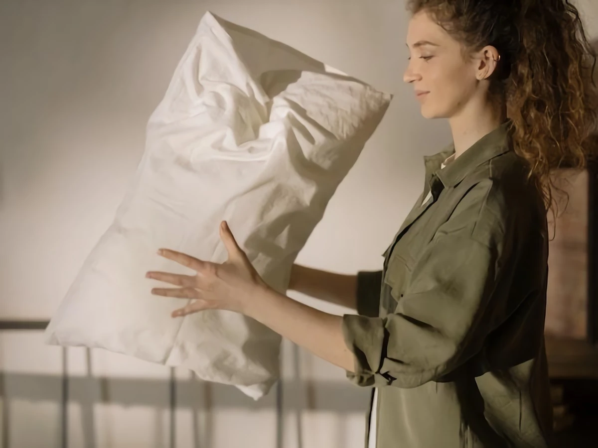 woman holding her pillow in between hands