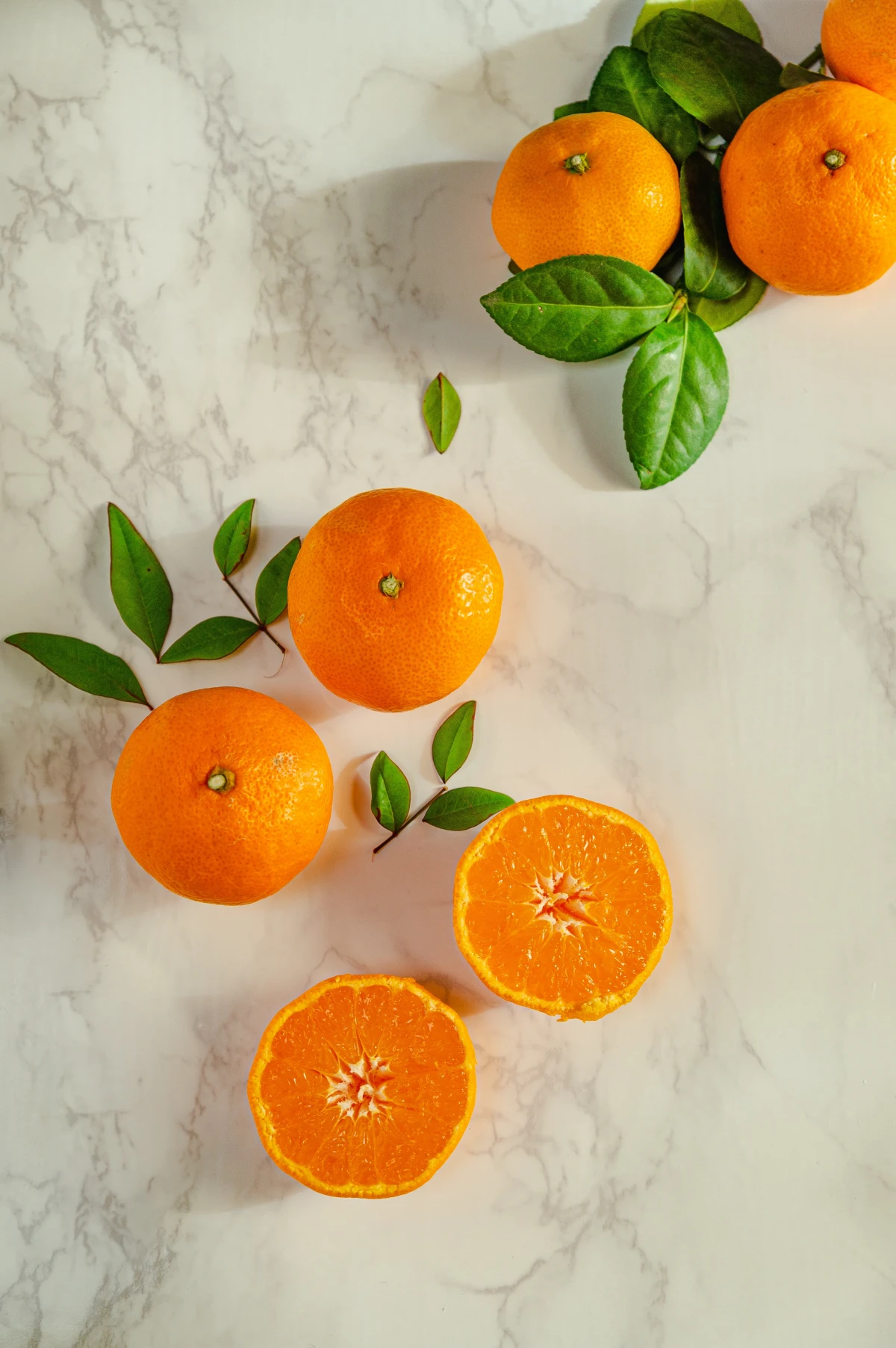 mandarins whole and halved on marble counter