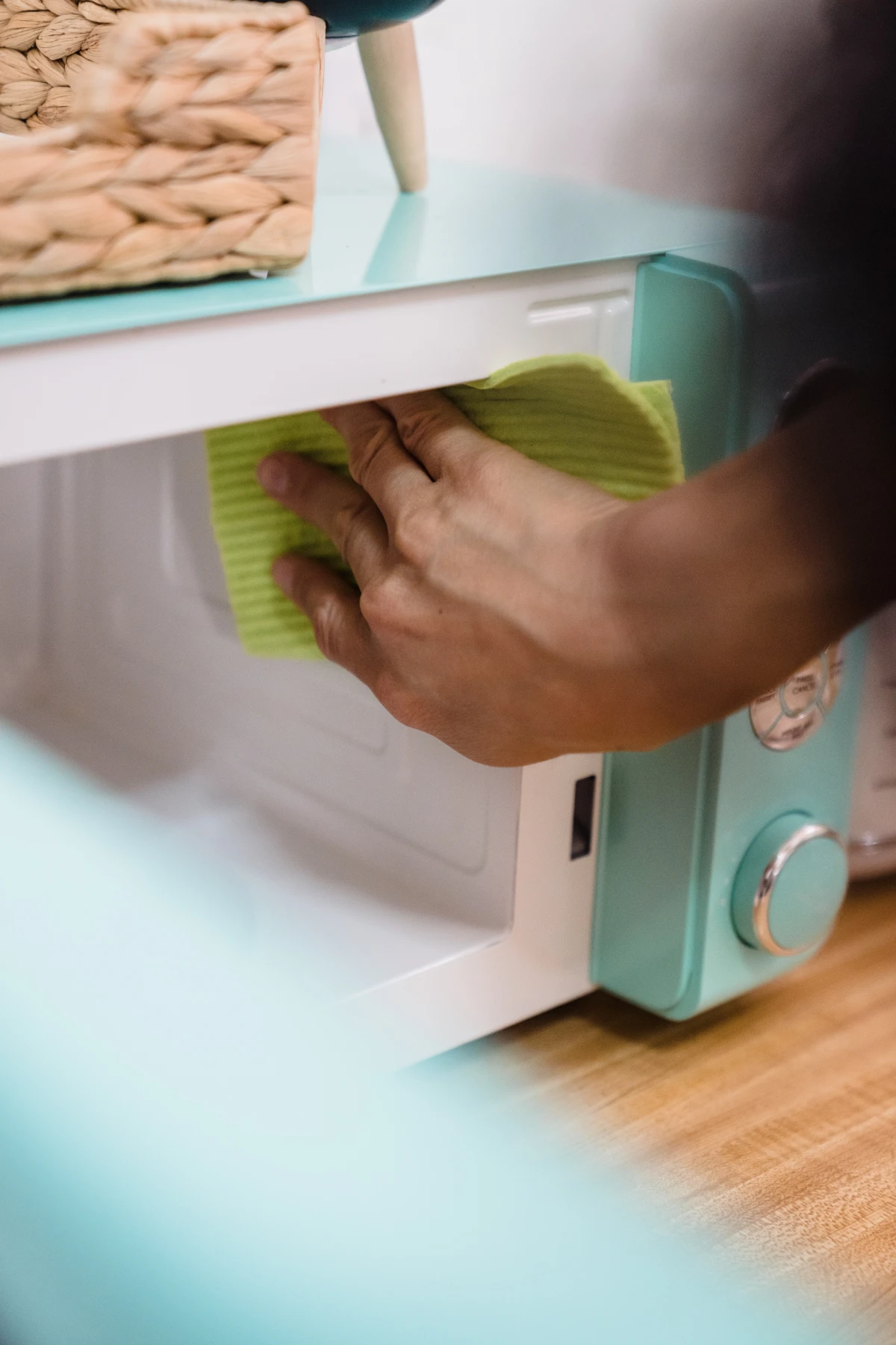 person cleaning inside of microwave