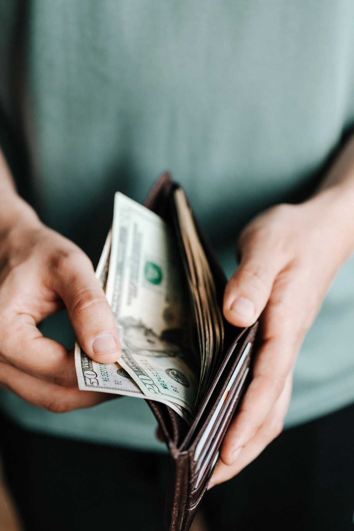 person holding a wallet with money