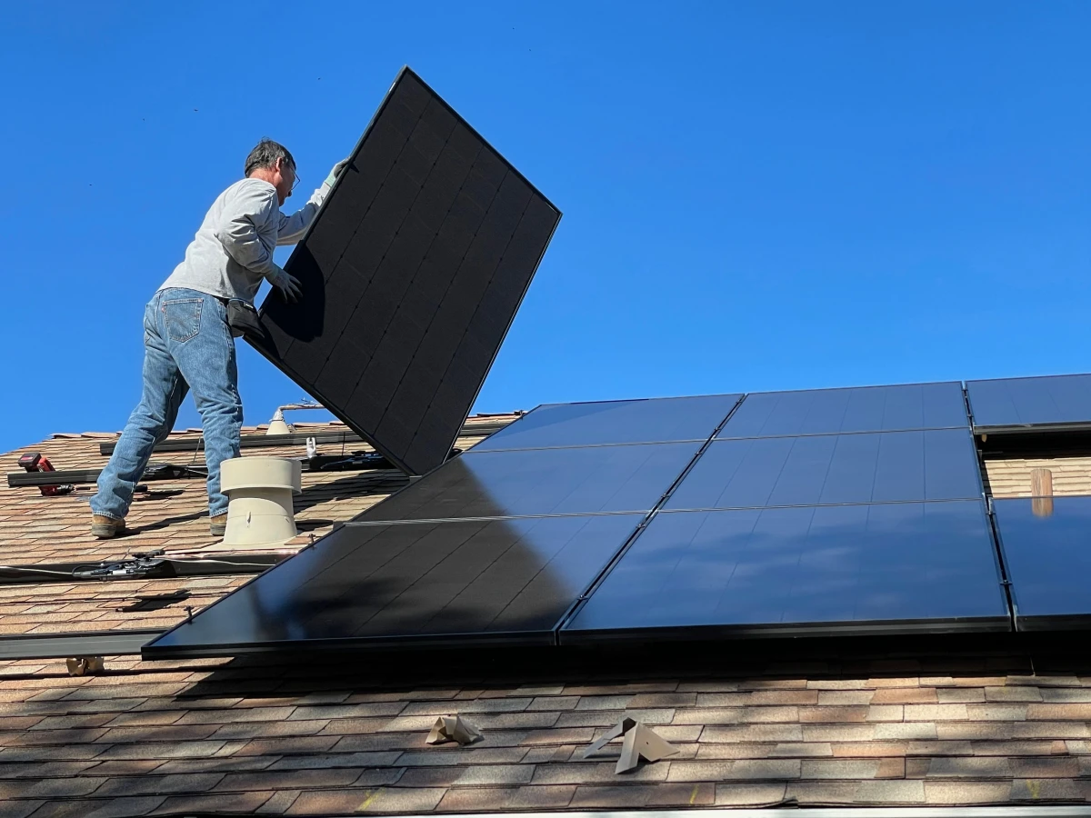 person putting solar panels on roof