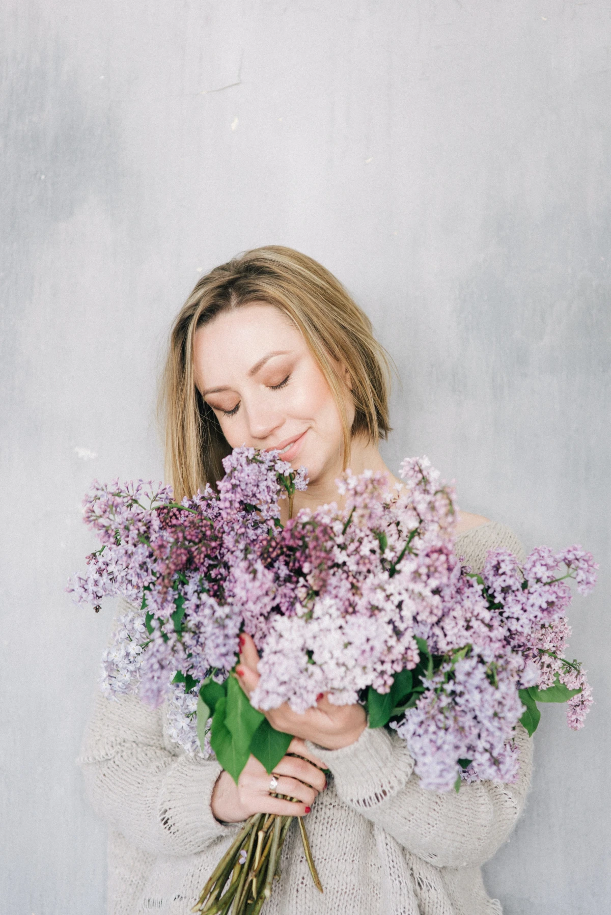 plants you should never prune in early spring woman hugging lilac bouquet