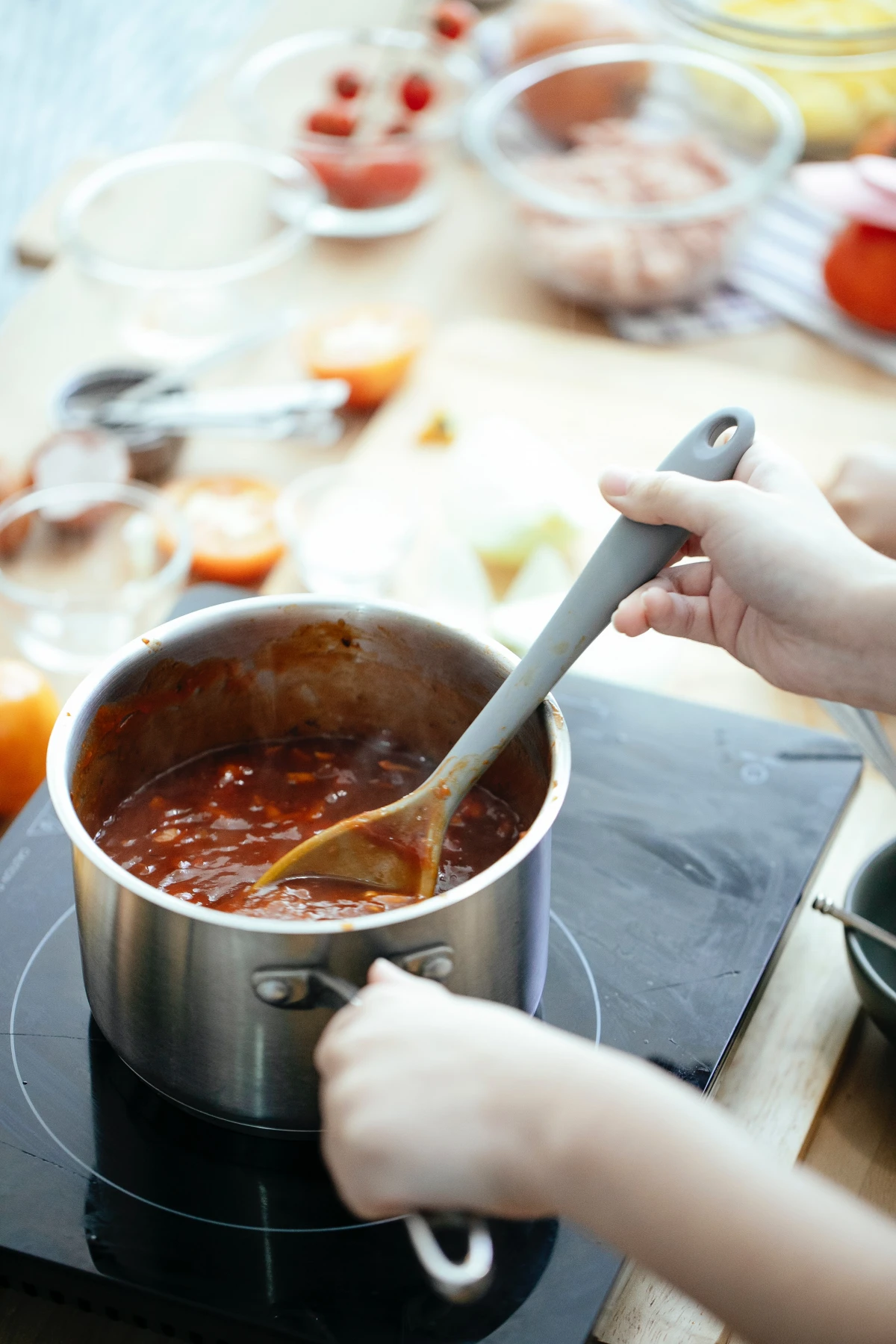 stirring a pot of tomato sauce