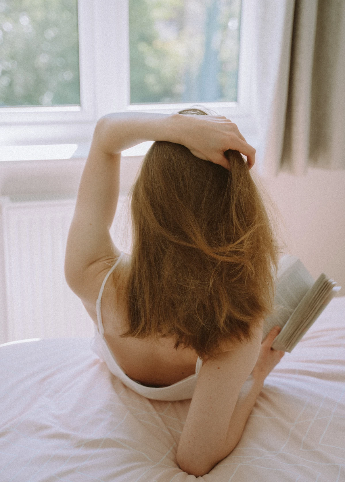woman reading a book on bed