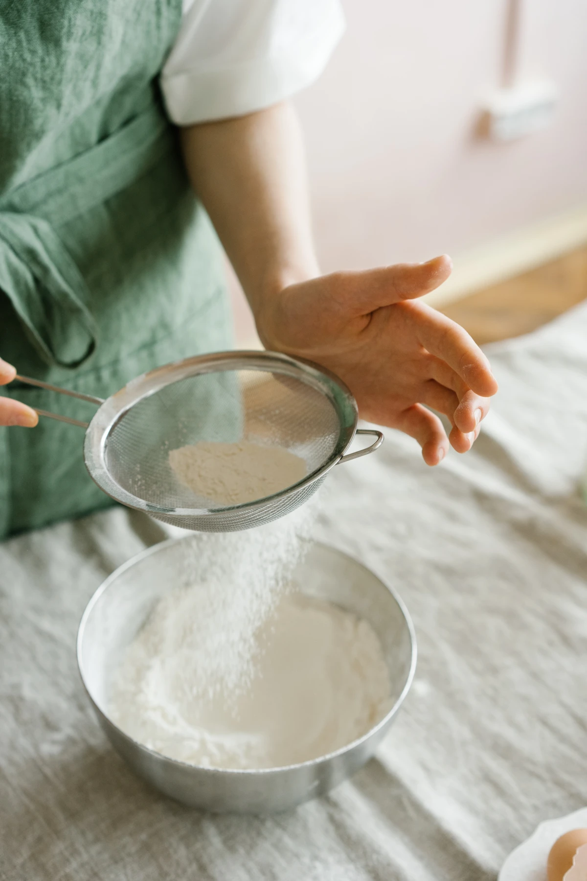 woman sifting flour in a bowl