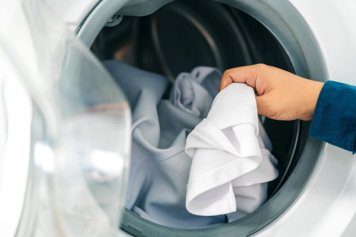 dryer hacks person putting clothes in the dryer
