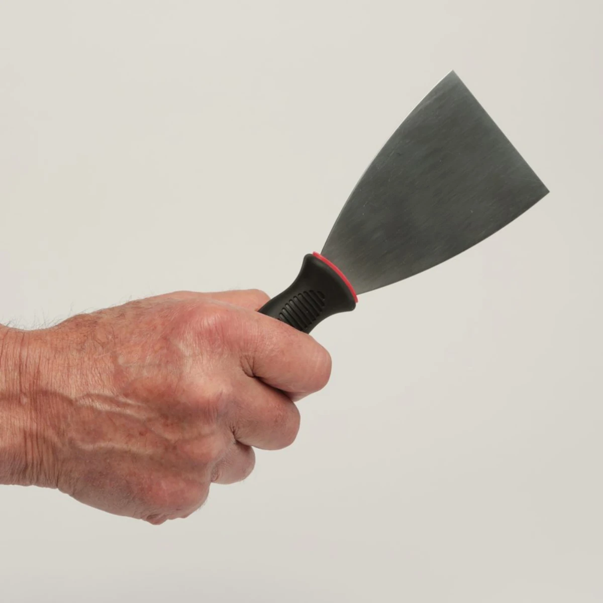 how to clean quartz countertops hand holding a putty scraper