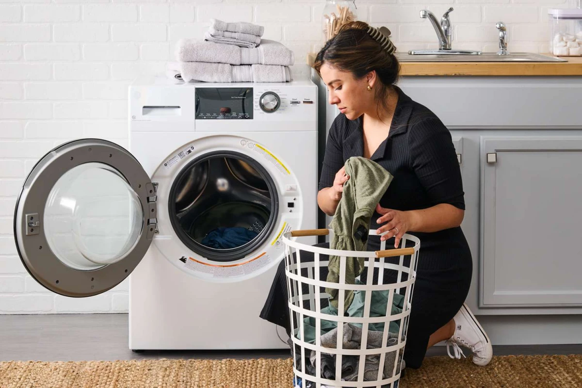 woman doing laundrey in front of dryer