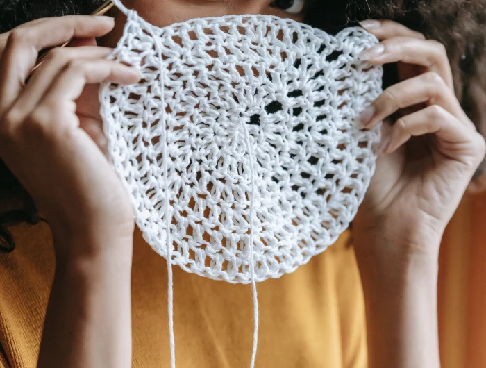 woman holding her crochet in front of her face