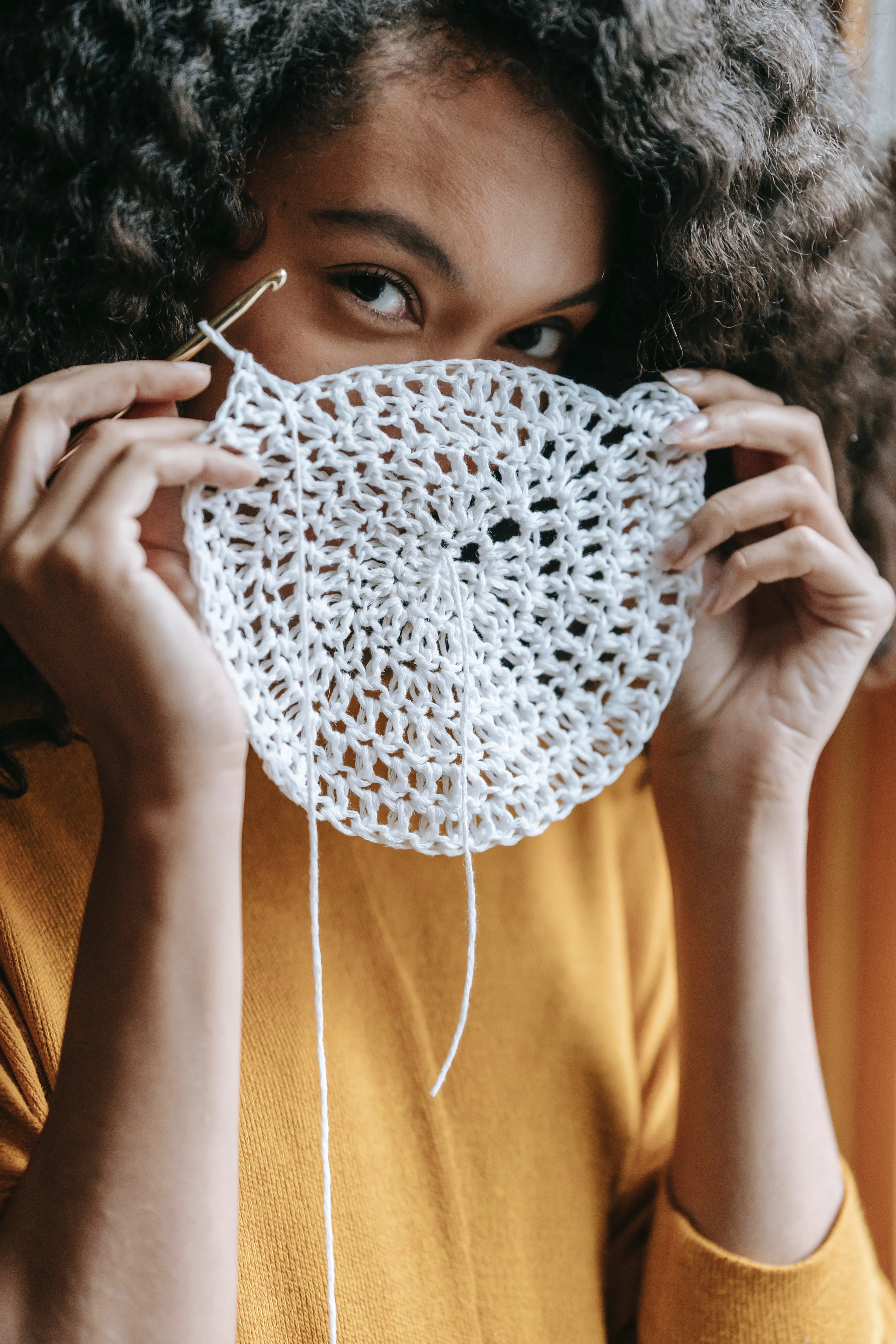 woman holding her crochet in front of her face