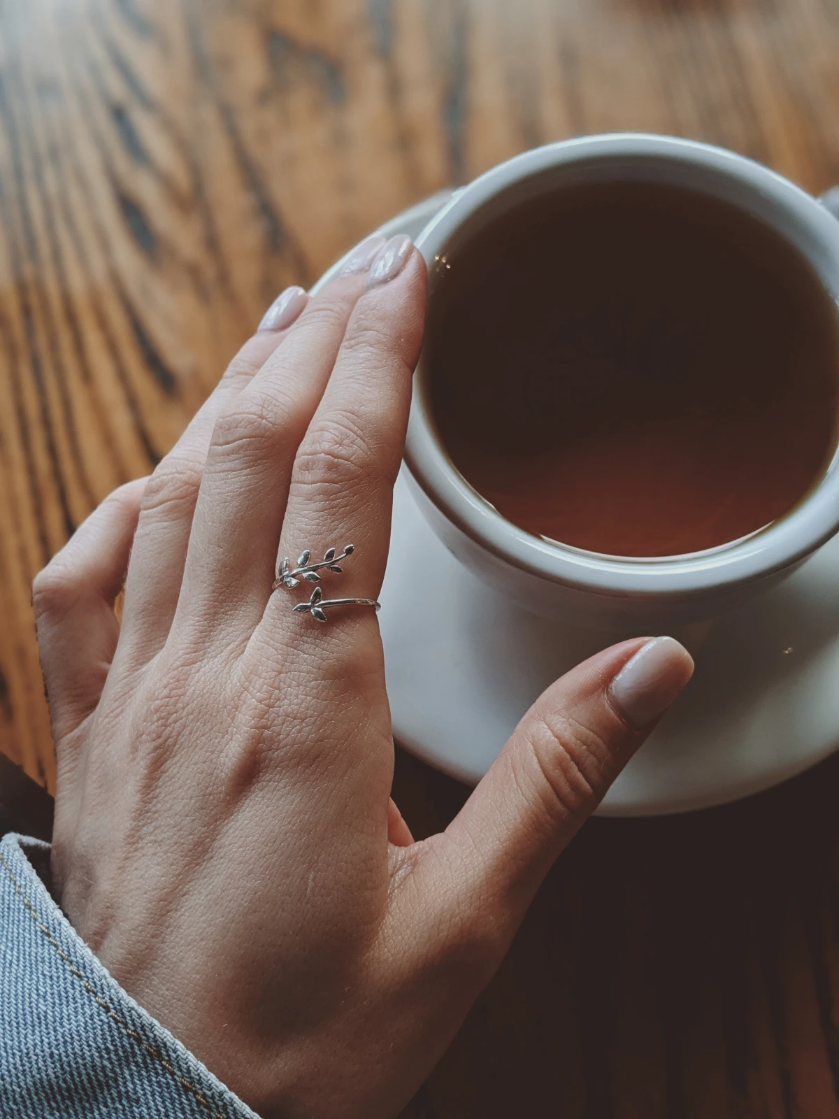 woman touching cup full of tea