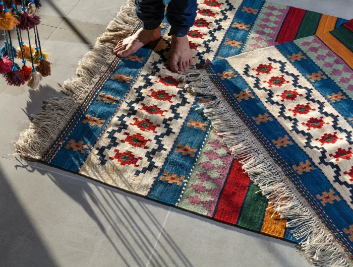 barefoot person on colorful rugs
