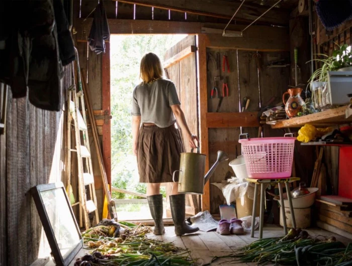 cluttered garden shed with woman standing in the middle