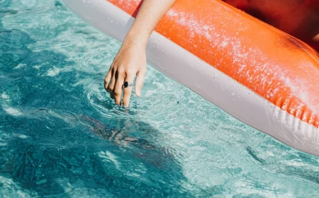 person with hand in swimming pool