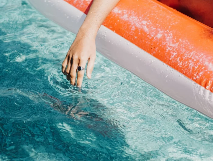 person with hand in swimming pool