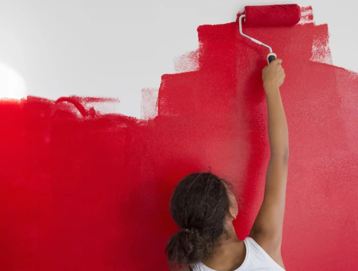 how to make paint dry faster woman painting a wall bright red