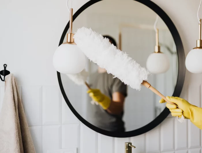person dusting mirror