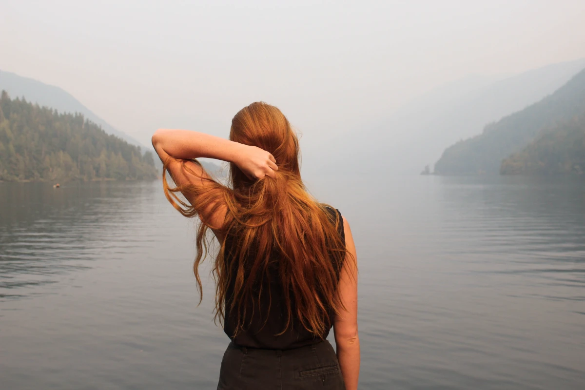 woman with ginger hair standing in lake