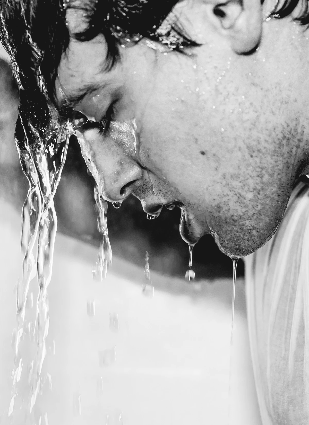 black and white photo of man showering