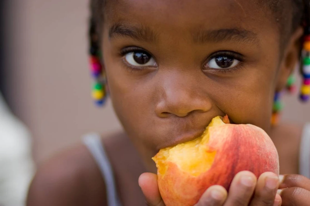kid eating a peach
