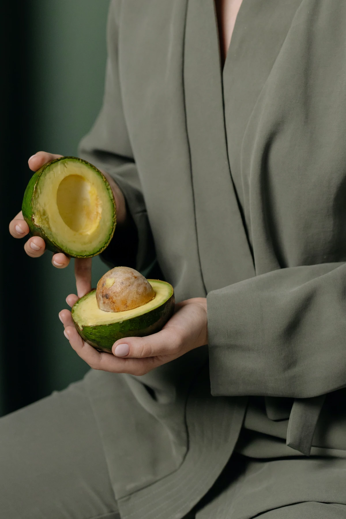 woman opening up avocado
