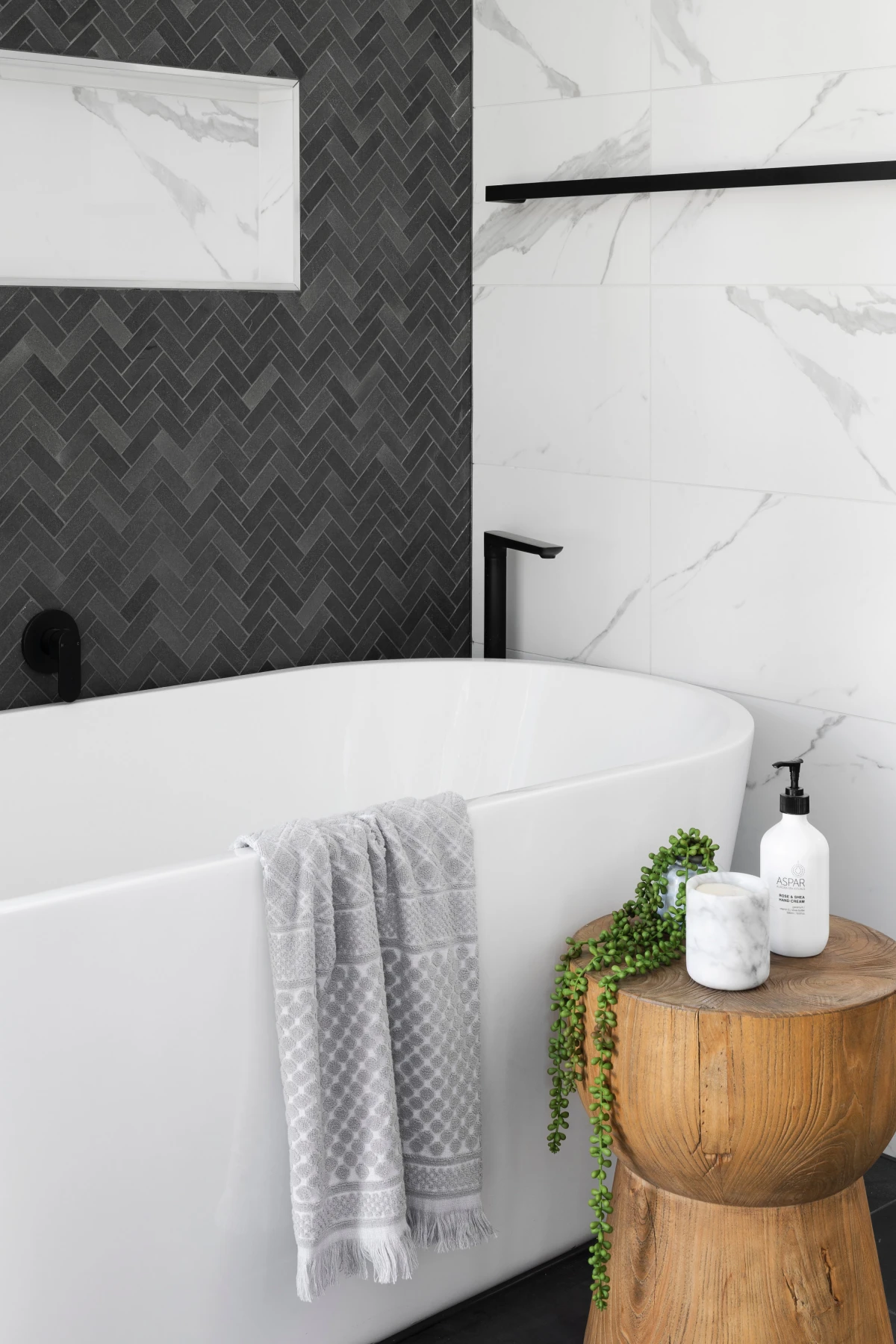 bathroom with gray tiles and white bath