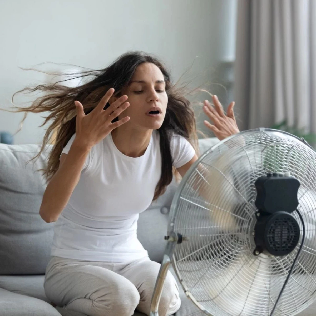 how to cool down a room woman using a fan