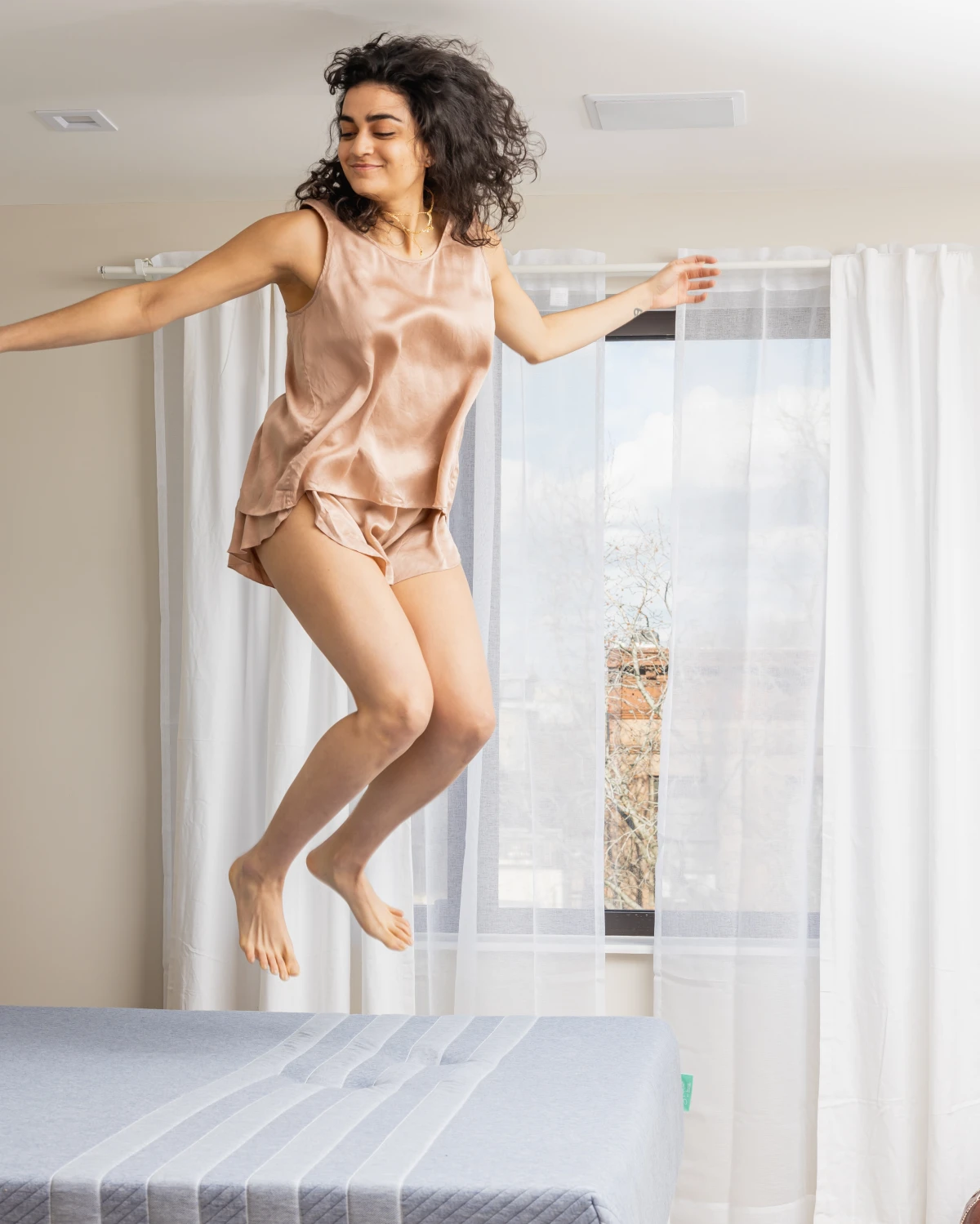 woman jumping on bed