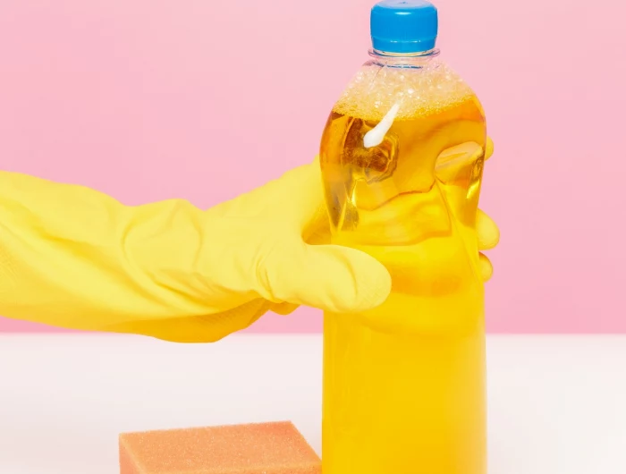 the woman's hand cleaning on a pink background. cleaning or housekeeping concept