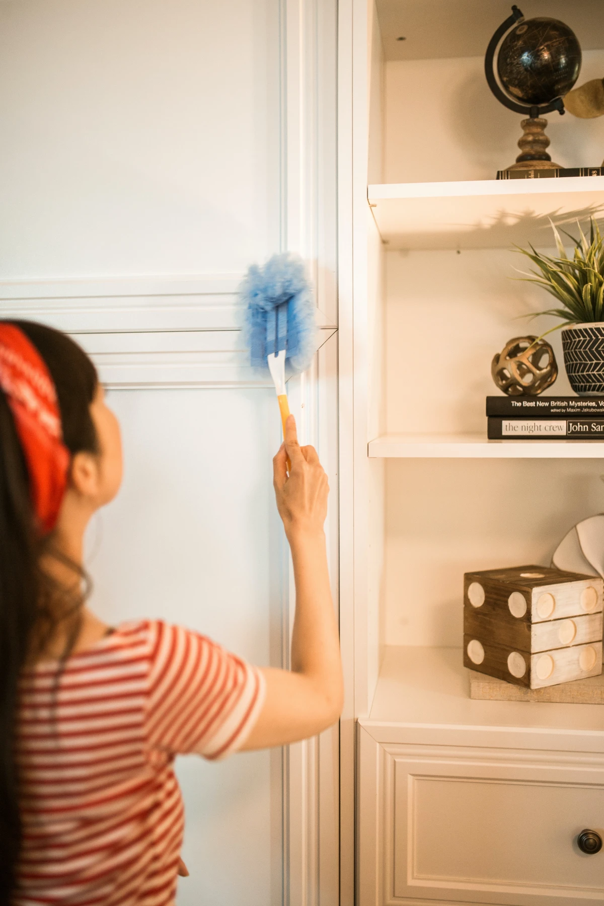 dusting mistakes woman dusting shelves