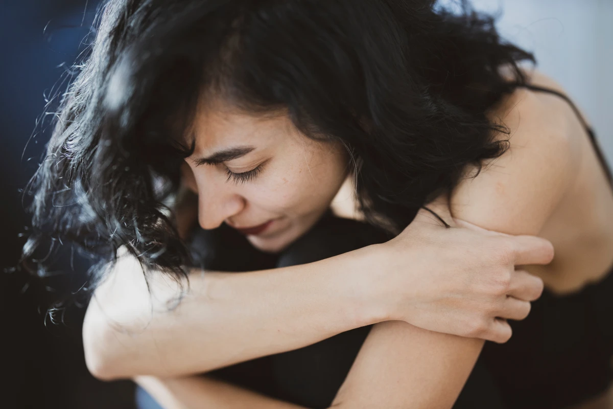 woman crying into arm