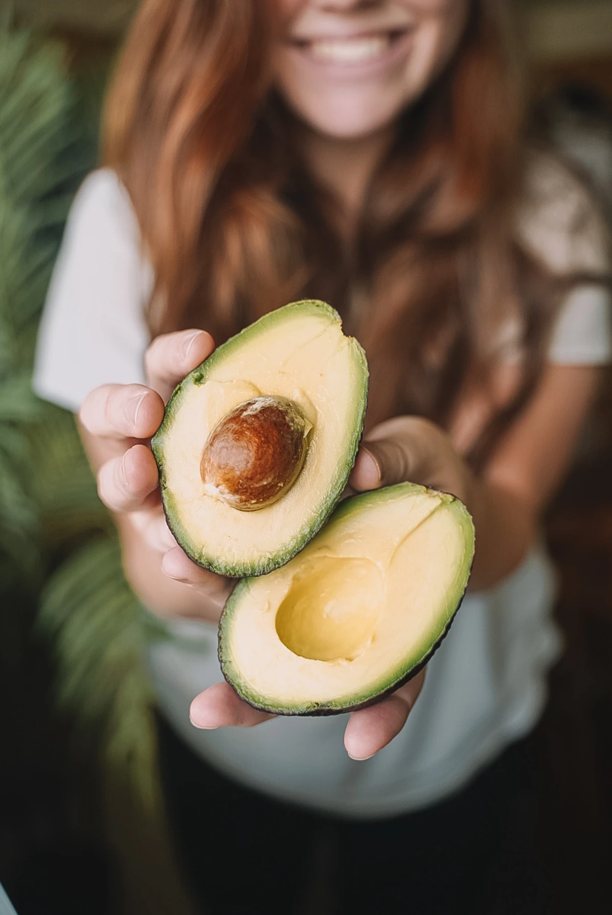 woman holding an avocado