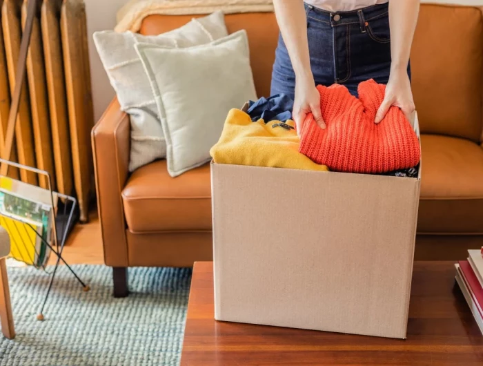 declutter before fall woman decluttering in box