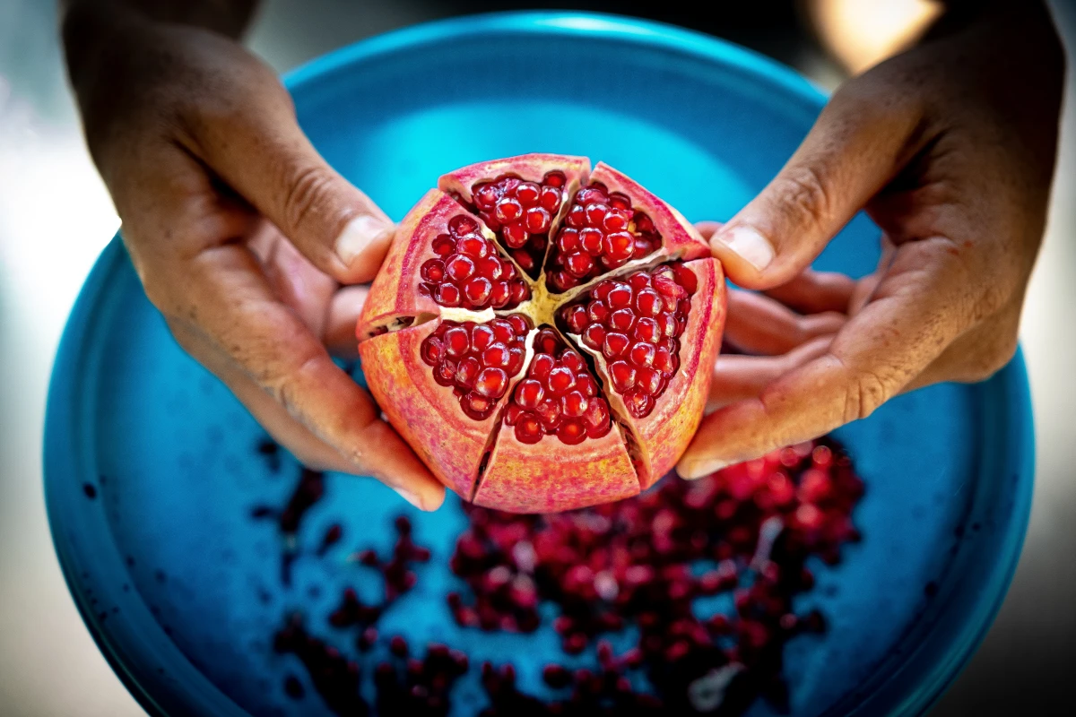 fall superfoods person holding cut pomegranate