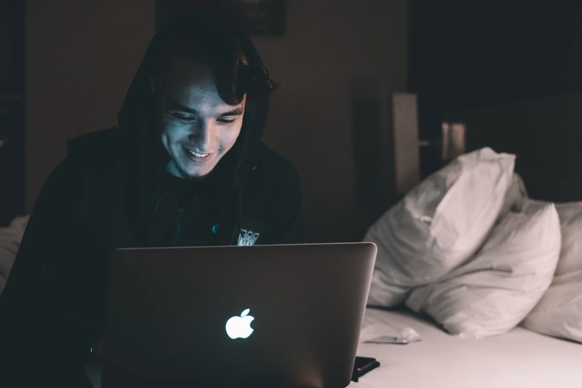 fix your sleep schedule person sitting in bed on laptop