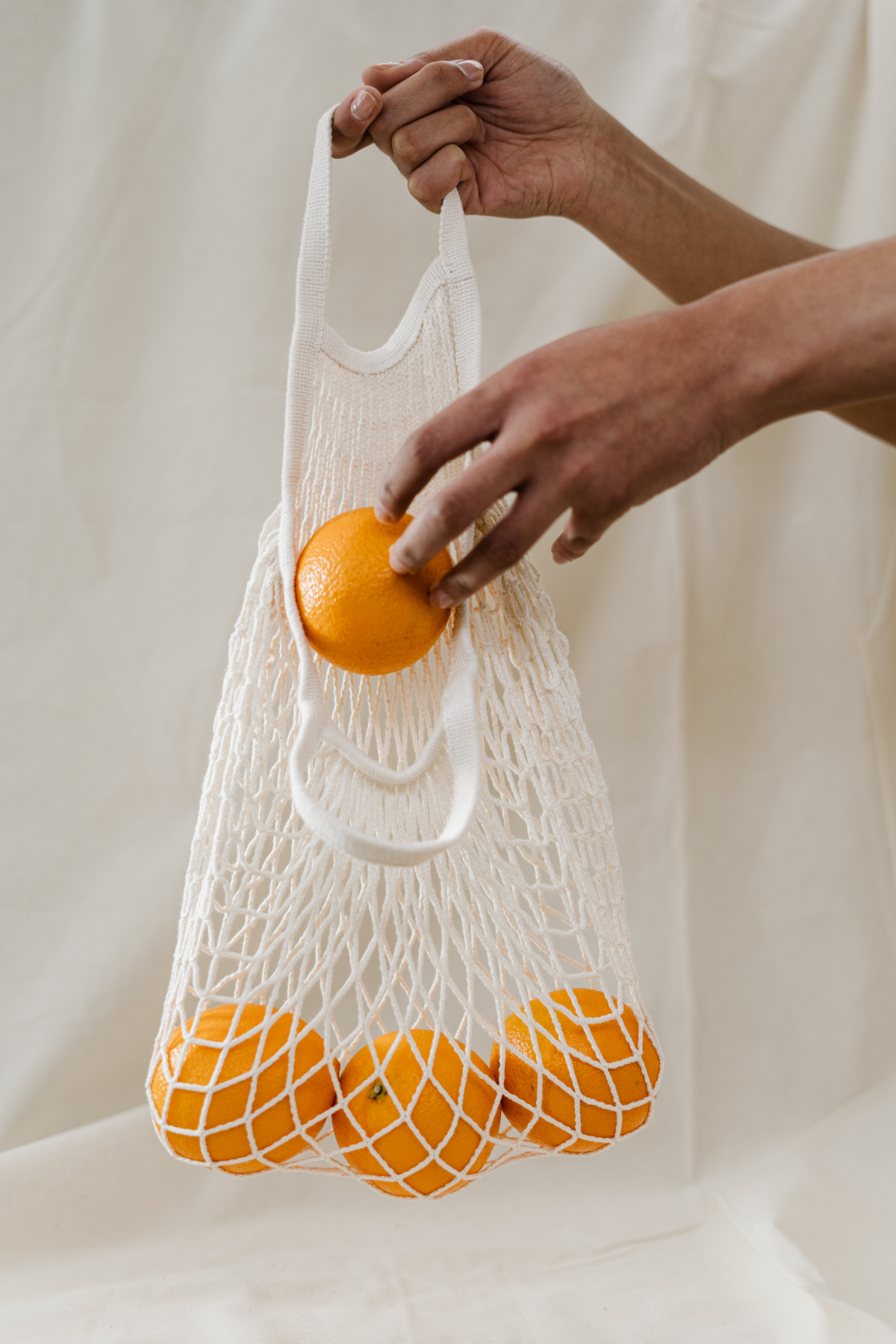 fruits that are in season in winter putting oranges in a bag