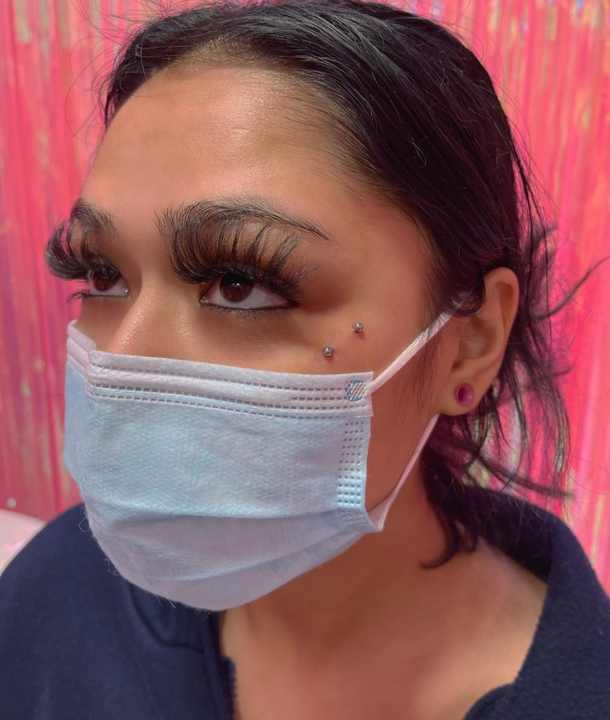 9 woman with mask lashes and face piercing