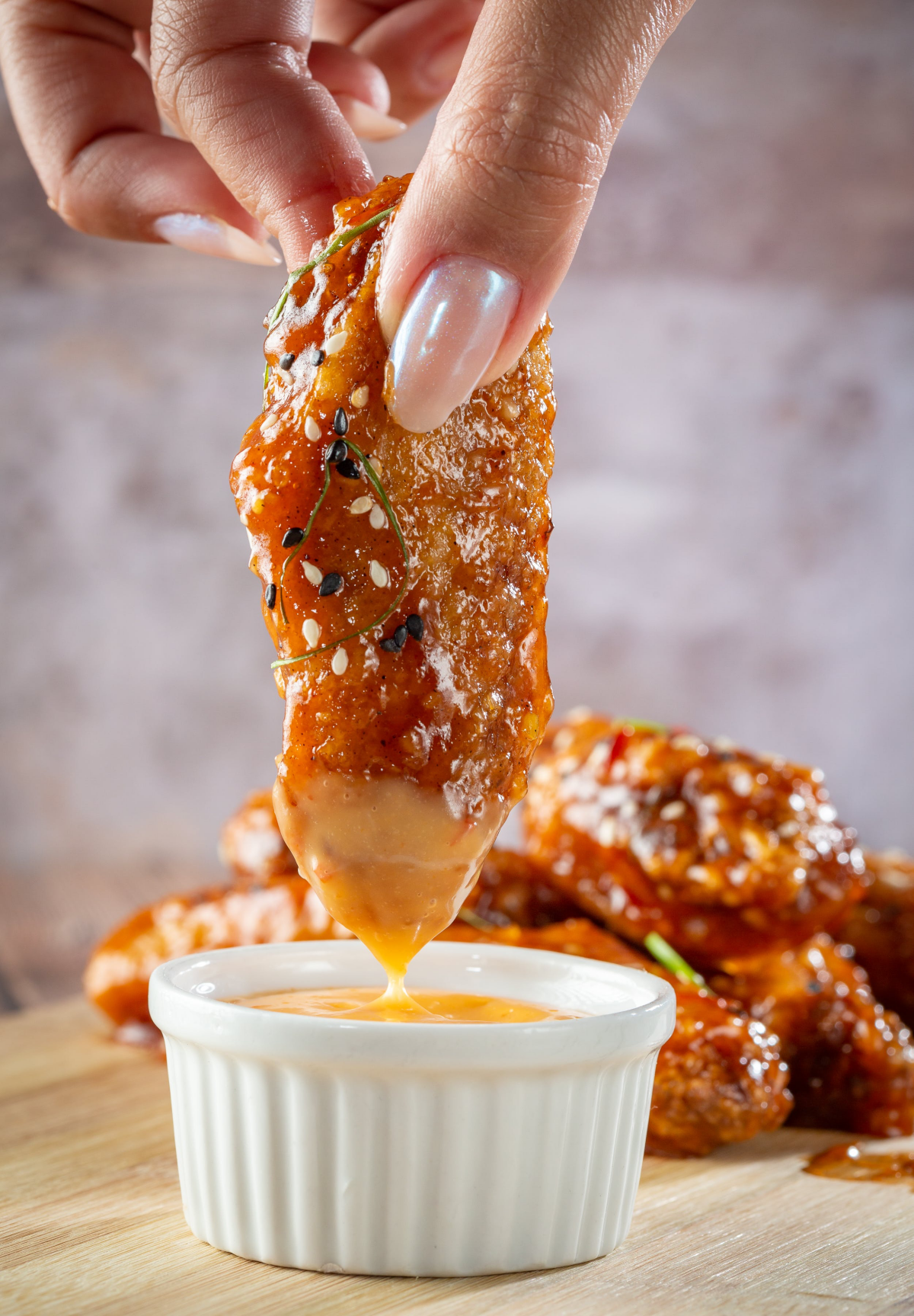 dipping chicken wing in sauce