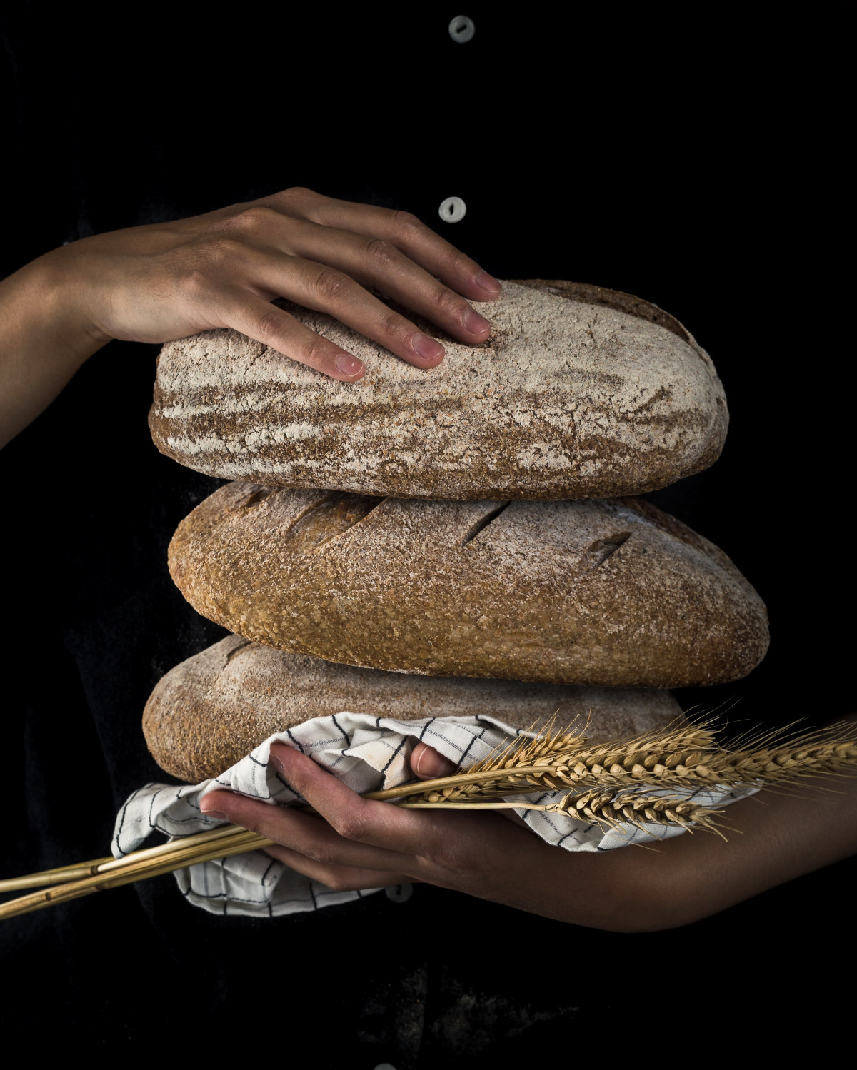 person holding three loafs of bread