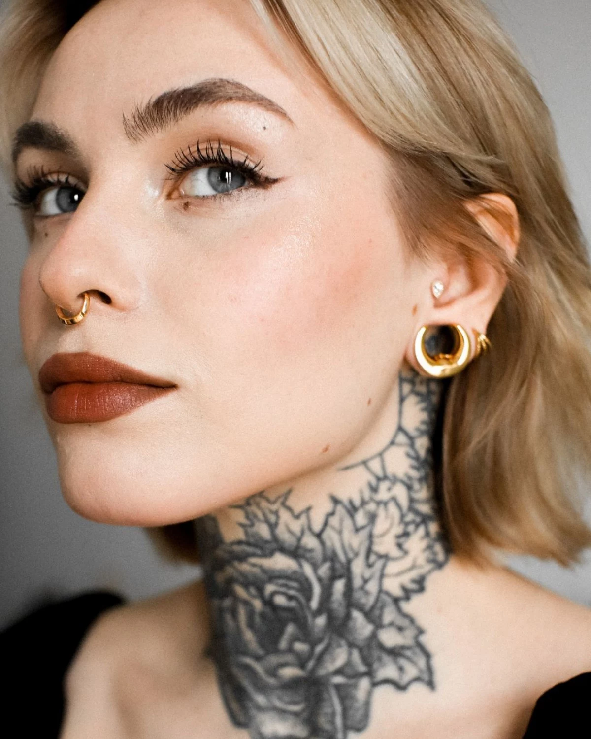 septum piercing woman with tattoo and piercing