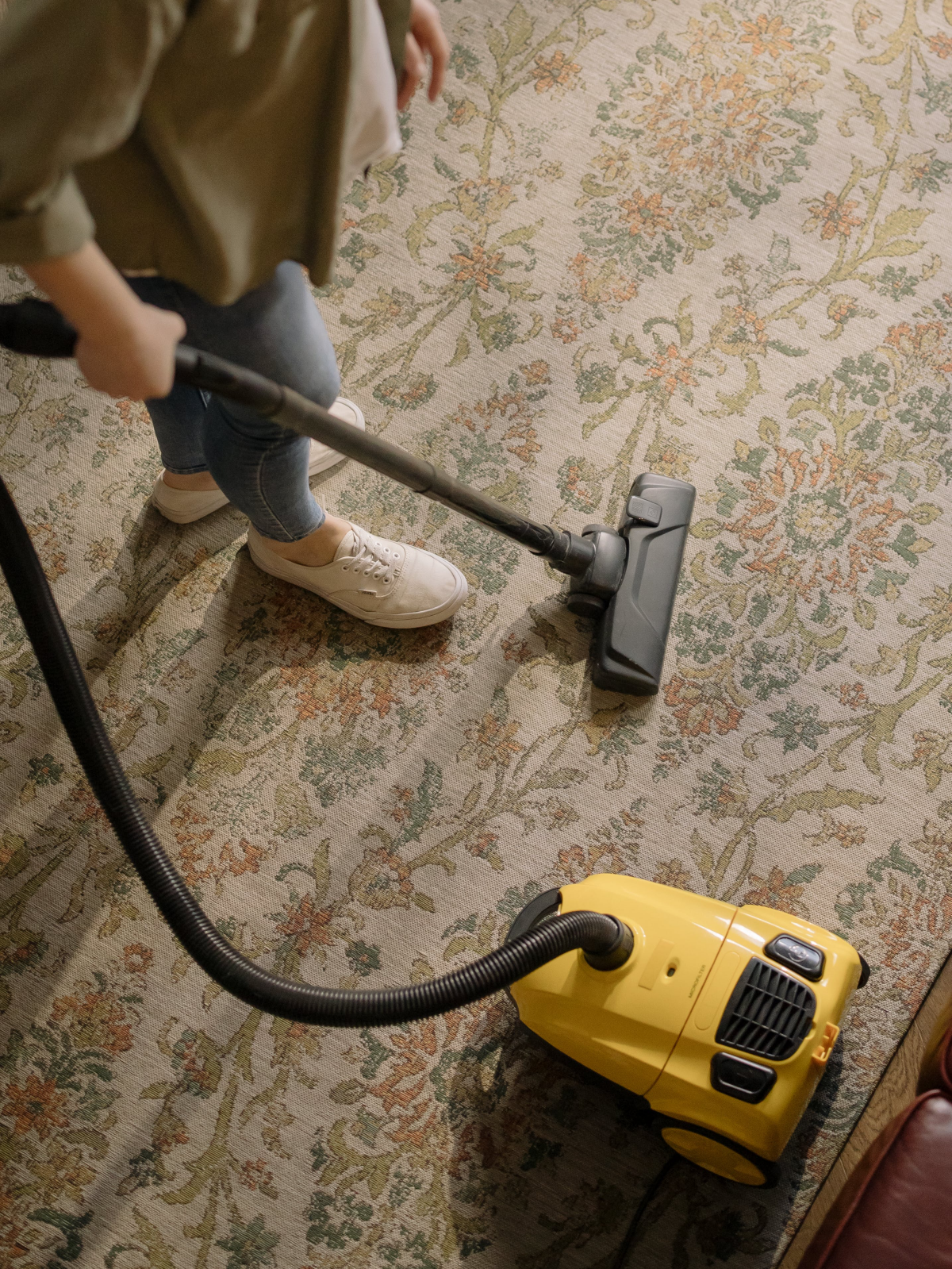 woman using vacuum on rug