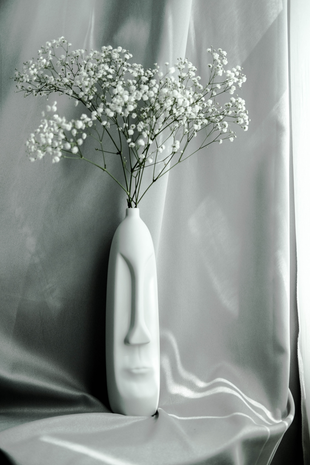 baby breath in a white face vase