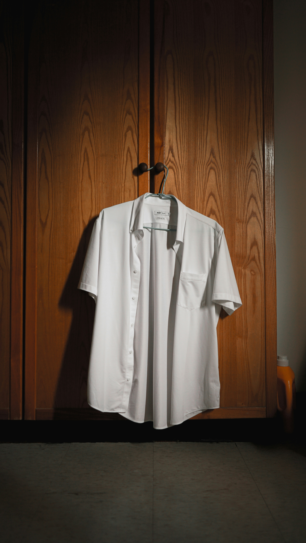 dress shirt hanging from cabinet